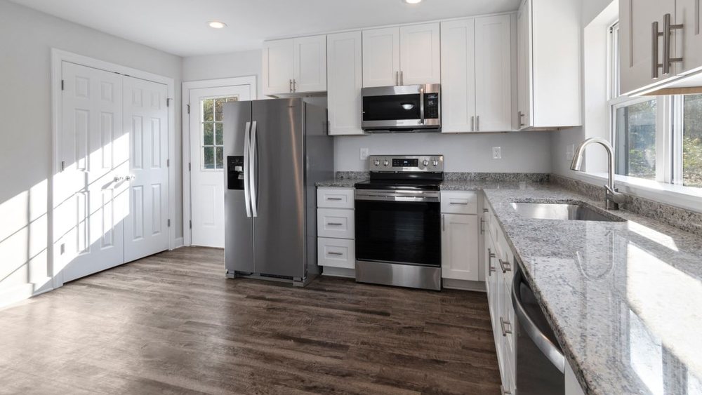 A finished open kitchen with an island between the range and the sink
