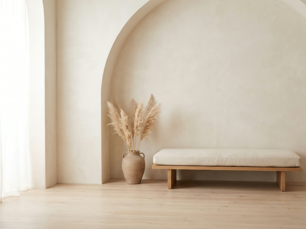 A calm cream interior with a soft arch and quiet light